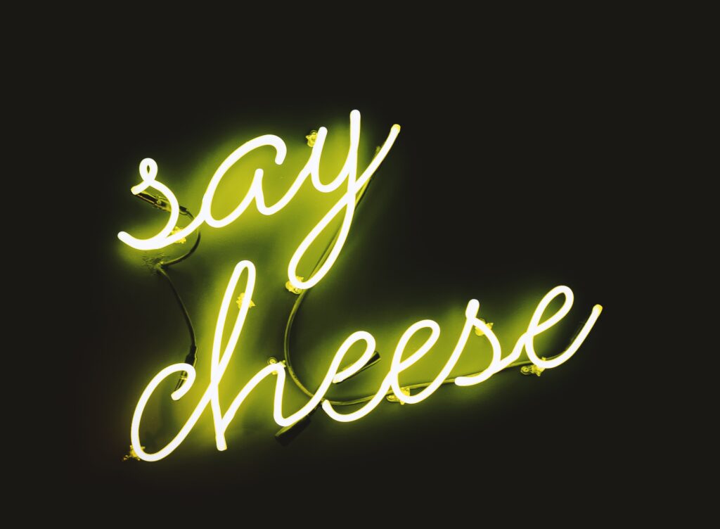 neon sign that says say cheese, to cheer business women up